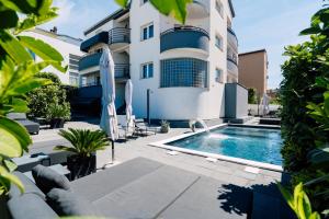 a swimming pool in front of a building at Holiday Apartments Amarilis in Pakoštane