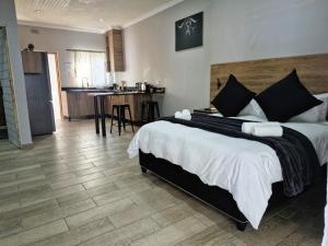 a bedroom with a large bed and a kitchen at Casa Kruger Lodge in Phalaborwa +19 photos