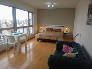 a bedroom with a bed and a couch and a table at Quartier San Telmo Luxury Pool Gym & Spa, piscina climatizada in Buenos Aires +41 photos