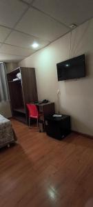 a room with a bed and a desk and a television at Hotel La Costa in Rio de Janeiro