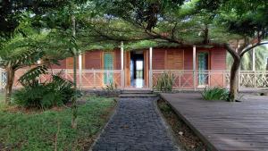 a small red house with a porch and a wooden walkway at Roça Monte Forte in Neves +21 photos