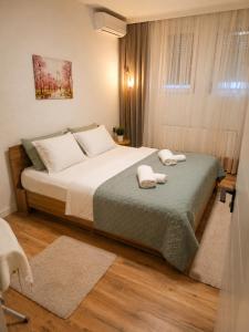 a bedroom with a bed with two towels on it at Nesi apartmenti in Prishtinë