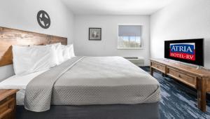 a hotel room with a large bed and a tv at Atria Hotel and RV McGregor in McGregor +26 photos