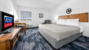 a hotel room with a bed and a flat screen tv at Atria Hotel and RV McGregor in McGregor