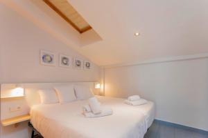 a bedroom with a white bed with two towels on it at Stancia Carmen in Valencia