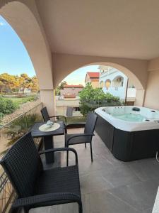 a hot tub on a patio with chairs and a table at Villa Asa with private Jacuzzi in Vir