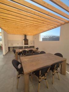 a dining room with wooden tables and chairs at Studio Distrito Cavancha 2 in Iquique