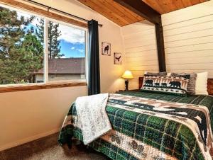 a bedroom with a bed and a large window at Cozy Pet Friendly Big Bear Cabin in Big Bear City