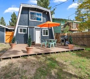 a house with a patio with an orange umbrella at Cozy Pet Friendly Big Bear Cabin in Big Bear City +13 photos