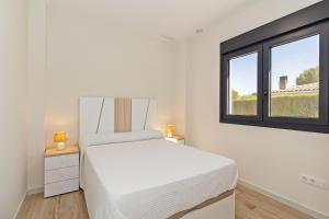 a white bedroom with a bed and a window at Oasis los Lagos in Alginet +31 photos