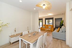 a dining room and living room with a table and chairs at Oasis los Lagos in Alginet
