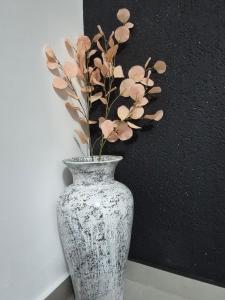 a vase with a plant in it next to a wall at STD AFRODITA Apartment & Garden in Vrdnik