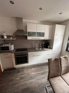 a kitchen with white cabinets and a sink at Ferienwohnung Marcello in Adenau