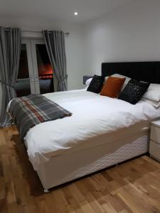um quarto com uma cama branca com almofadas em Langley Apartment em Inverness