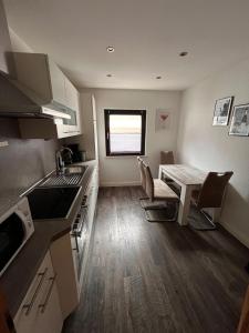 a kitchen with a table and a dining room at Ferienwohnung Marcello in Adenau +5 photos