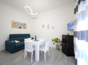 a living room with a white table and a blue couch at Bellamorèa in Noto