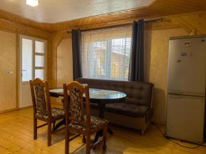 a kitchen with a table and a couch and a refrigerator at Під соснами in Krivorovnya