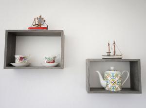 two wooden shelves with cups and a vase on a wall at Bellamorèa in Noto