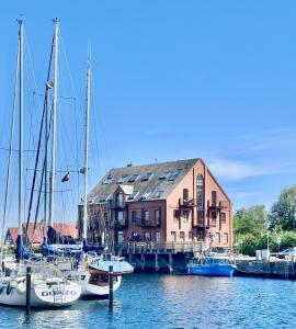 a group of boats docked in front of a building at meerBLICK in Orth