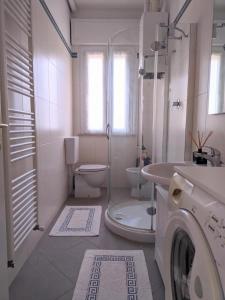 a bathroom with a washing machine and a toilet at Maréthias in Punta Marina