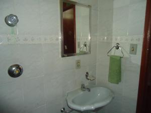 a white bathroom with a sink and a mirror at Altos da Grupiara - Diamantina in Diamantina +56 photos