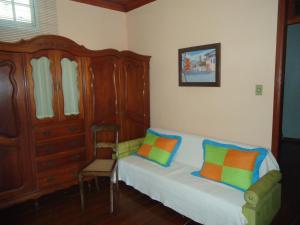a bedroom with a bed and a chair with colorful pillows at Altos da Grupiara - Diamantina in Diamantina