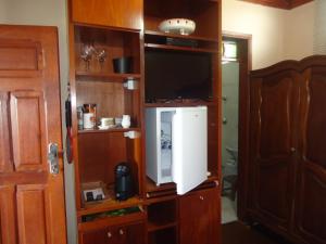 a room with a tv in a wooden cabinet at Altos da Grupiara - Diamantina in Diamantina
