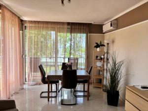 a dining room with a table and chairs and a window at Gruber Apartman in Siófok