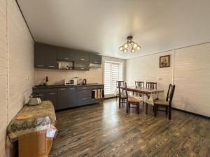 a kitchen and dining room with a table and chairs at Під соснами in Krivorovnya