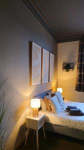 a bedroom with a bed with two pictures on the wall at LA SUITE 159 in Namur