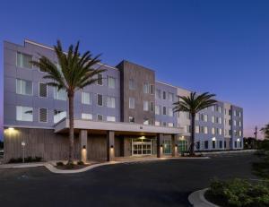 a large building with palm trees in front of it at Drury Inn & Suites Destin Miramar Beach in Destin