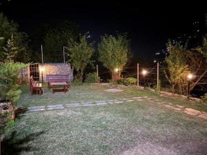 a purple bench sitting in a yard at night at Gound Floor Studio Appartment in Kulu