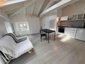 a room with a bed and a table and a kitchen at Appartamento San Rocco in Intra