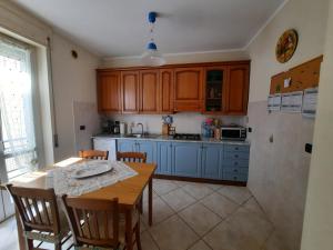 a kitchen with blue cabinets and a table with chairs at A casa di Ely in Aulla +8 photos