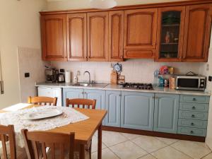 a kitchen with wooden cabinets and a wooden table with a tableablish at A casa di Ely in Aulla