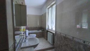 a bathroom with two toilets and a sink and a mirror at A casa di Ely in Aulla