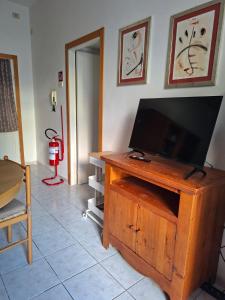 a living room with a flat screen tv on a wooden cabinet at NumanaPaceeMare in Numana