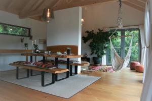 a living room with a table and benches and a hammock at Danuvius18 in Obernzell
