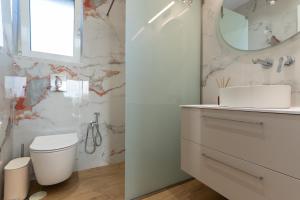 a bathroom with a toilet and a sink and a mirror at Casa Elaia in Pylos +31 photos