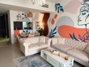 a living room with a couch and a painting on the wall at Al Raha Beach modern 1 bedroom near AD airport in Abu Dhabi