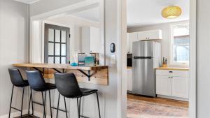 a kitchen with a bar with stools and a refrigerator at West Bench Retreat in Red Lodge