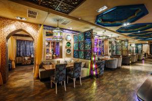 um restaurante com mesas, cadeiras e vitrais em ART Hotel em Astrakhan