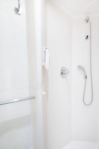 ein Bad mit einer Dusche und einer Glastür in der Unterkunft ibis budget Paris Porte De Montmartre in Paris