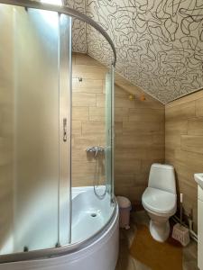 a bathroom with a shower and a toilet and a tub at Під соснами in Krivorovnya +32 photos