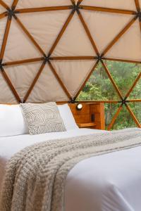 a bed in a tent with a large window at Naturave Monteverde - Treetop Cabins in Monteverde Costa Rica