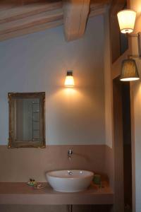 a bathroom with a sink and a mirror and lights at Le Moraiole in Massa Marittima
