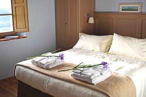 a bed with towels and purple flowers on it at Le Moraiole in Massa Marittima