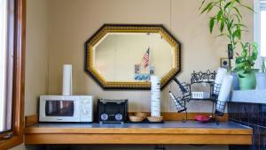 a microwave on a wooden table with a mirror at Chippewa Motel Mount Pleasant in Mount Pleasant +7 photos