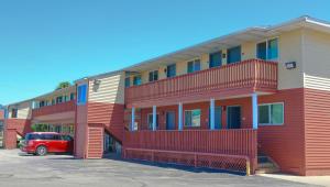 a red van parked in front of a building at Chippewa Motel Mount Pleasant in Mount Pleasant