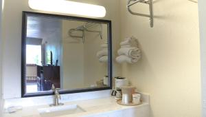 a bathroom with a sink and a large mirror at Chippewa Motel Mount Pleasant in Mount Pleasant